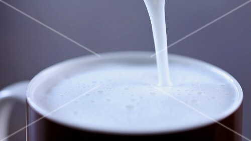 Warme Milch in eine Tasse giessen