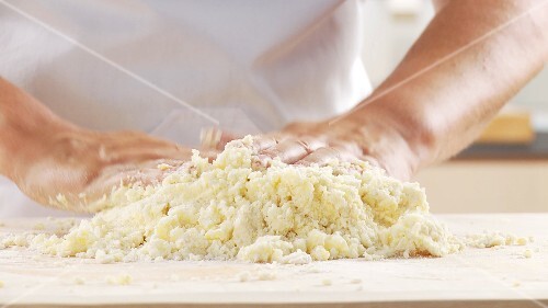 Gekochte Kartoffelmasse mit Mehl und Ei vermischen