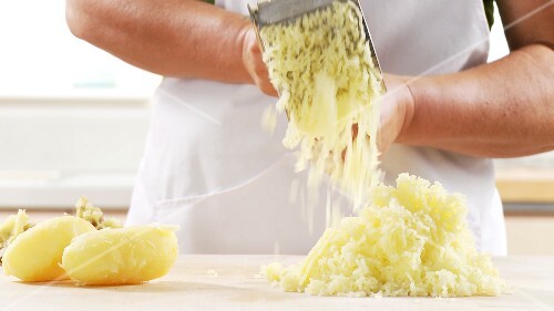 Cooked potatoes being mashed