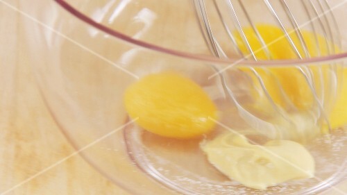 Ingredients for mayonnaise being mixed with a whisk