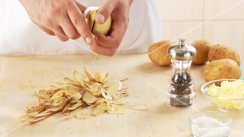 Kartoffeln schälen und in eine Schüssel mit kaltem Wasser legen
