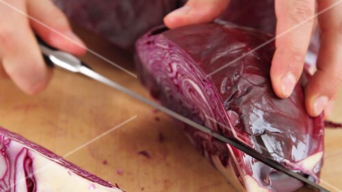 Red cabbage being quartered and the stem being removed