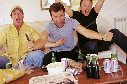 Cheering football fans watching television