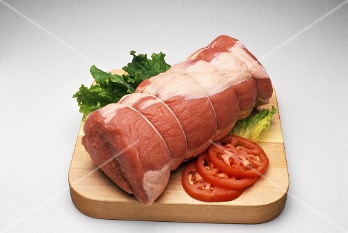 Large Roast on a Cutting Board; Tomato and Lettuce