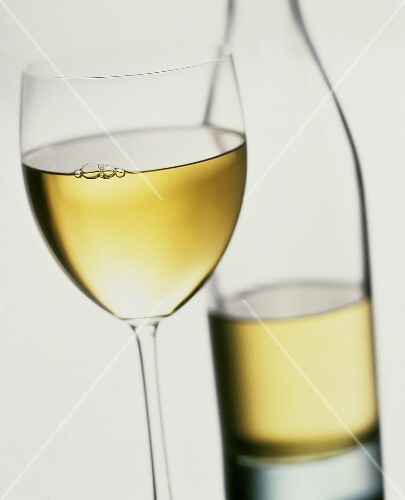 A Glass of White Wine; Bottle in Background