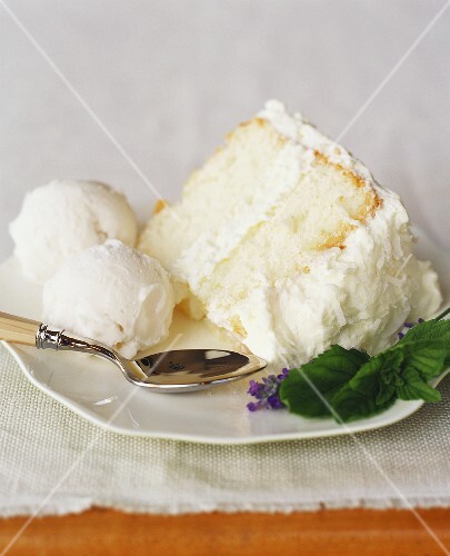 Slice of White Cake with Coconut Frosting and Two Scoops Coconut Gelato; Mint and Lavender Garnish