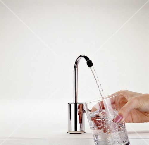 Faucet Dispensing Water into Hand-held Glass