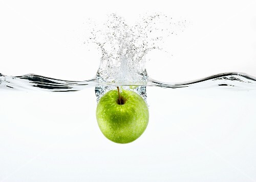 A Granny Smith Apple Splashing into Water