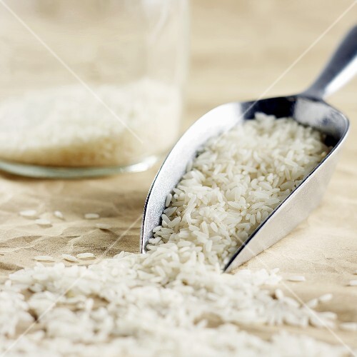 Long-grain rice on metal scoop and in jar