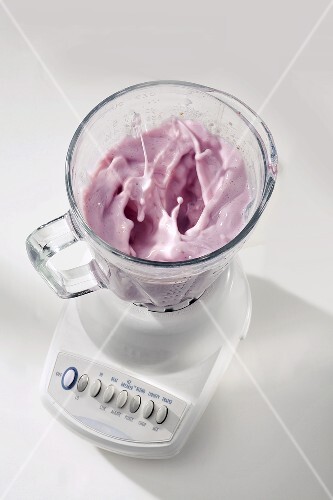 Berry Milk Shake Mixing in a Blender with No Cover, White Background