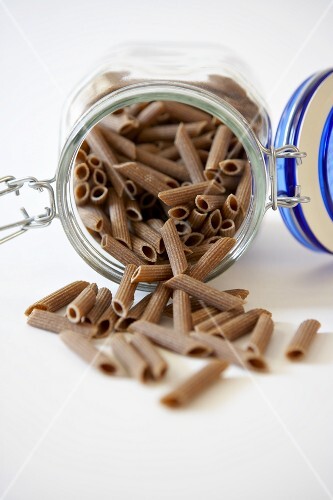 Whole Grain Penne Spilling from a Jar