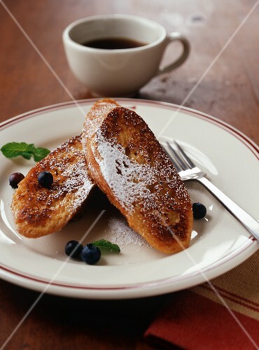 Two Pieces of French Toast with Powdered Sugar and Fresh Blueberries on a Plate