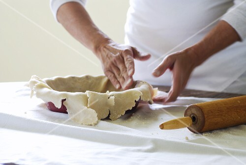 Kuchenform mit Mürbeteig auskleiden