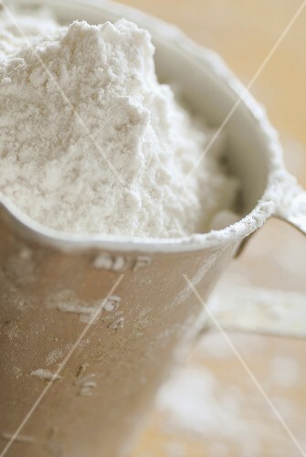Mehl in Messbecher aus Metall
