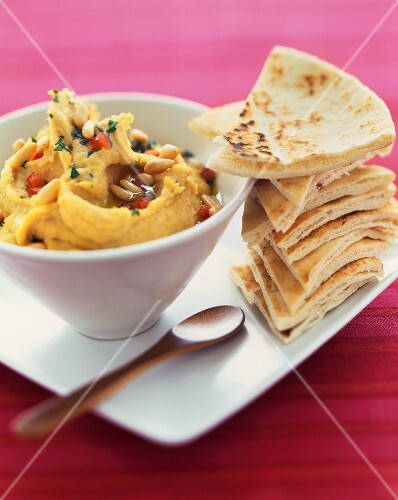 Bowl of Hummus with a Stack of Pita Triangles for Dipping