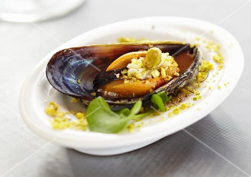 Single Mussel with Pistachio Nuts on Small White Dish
