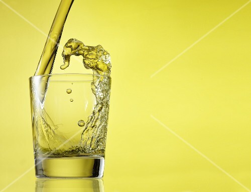 Scotch Pouring into a Glass on Yellow Background