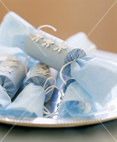 Delicate handmade tissue paper crackers on a silver platter