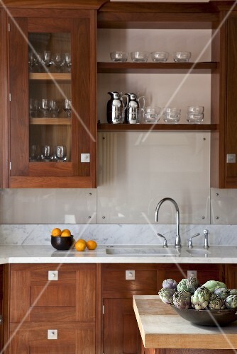 A bowl of artichokes sits on the central unit in the kitchen