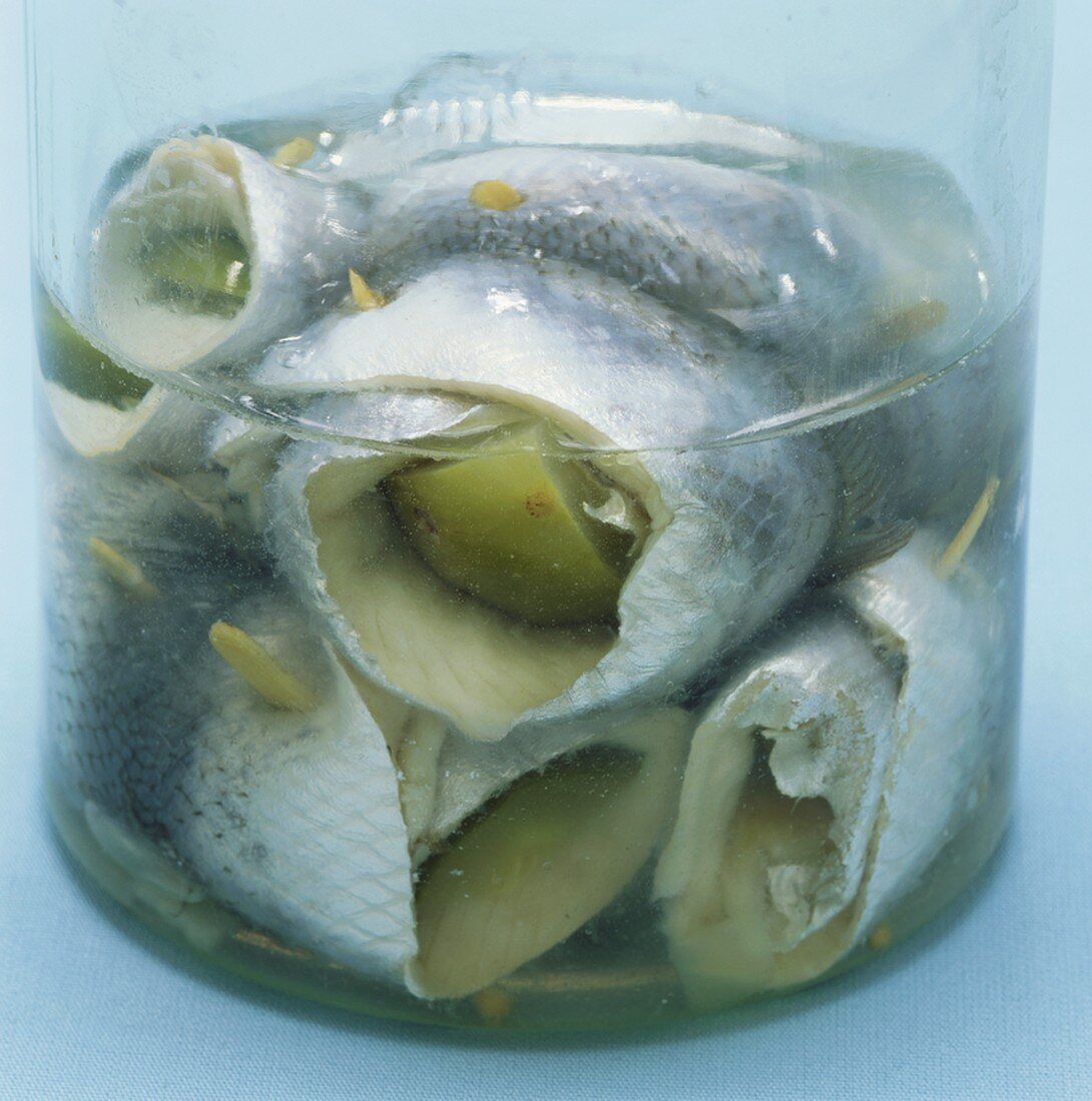 Several rollmops in a glass container