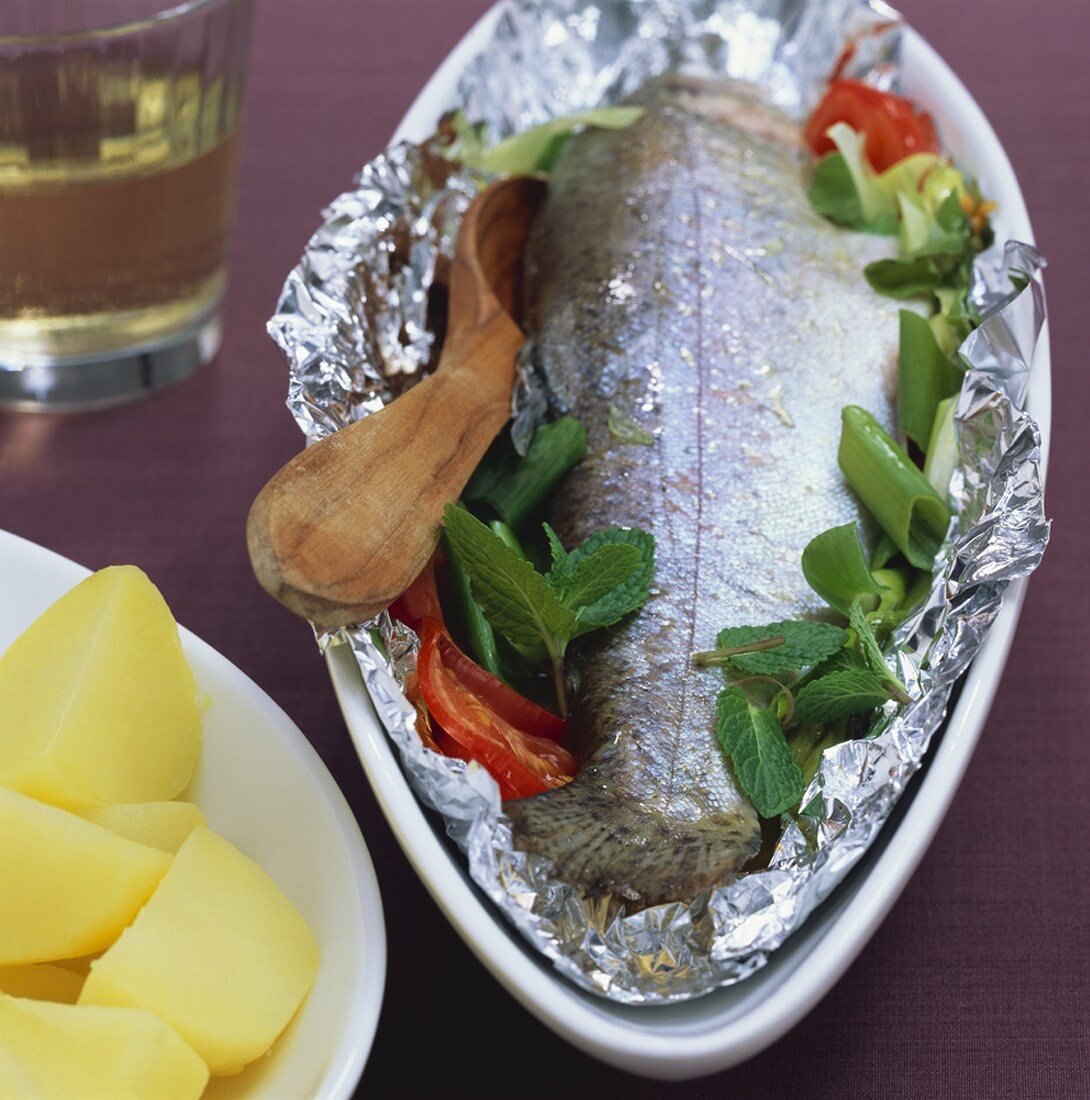 Trout with spring onions and tomatoes, cooked in foil