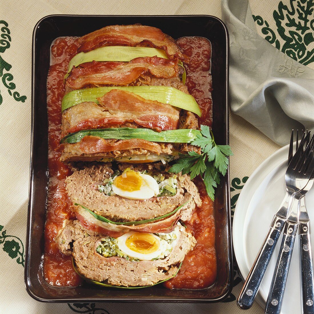 Würziger Hackbraten mit Eierfüllung auf Tomatensauce