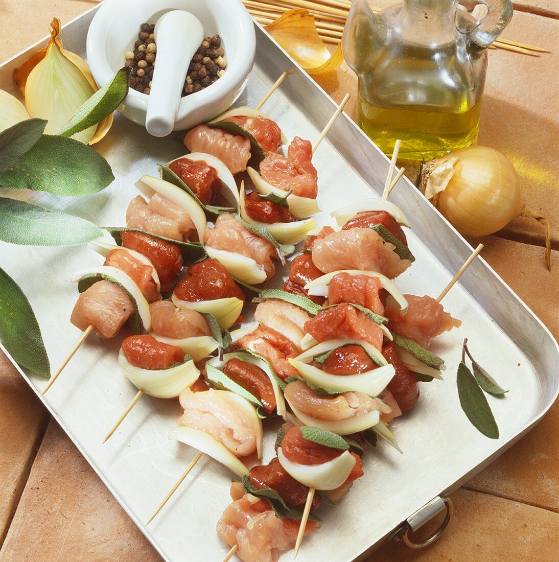 Raw mixed meat kebabs with onions and sage