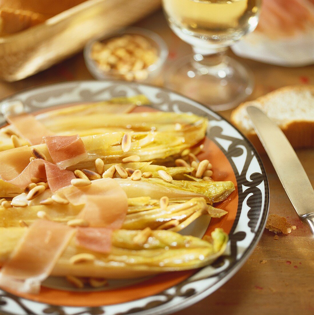 Baked chicory with pine nuts and Parma ham