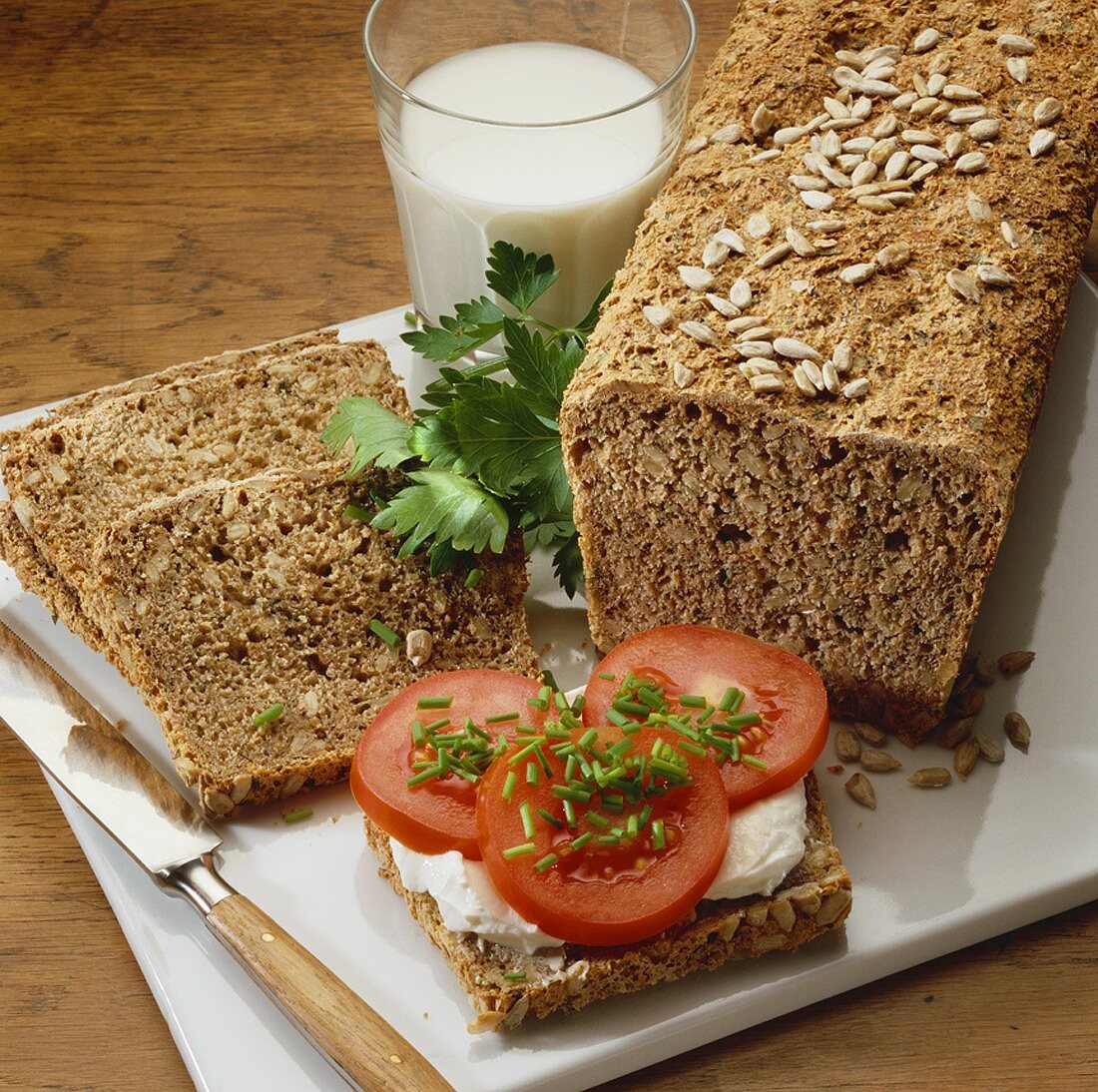 Wholemeal bread with herbs, one slice topped with tomato