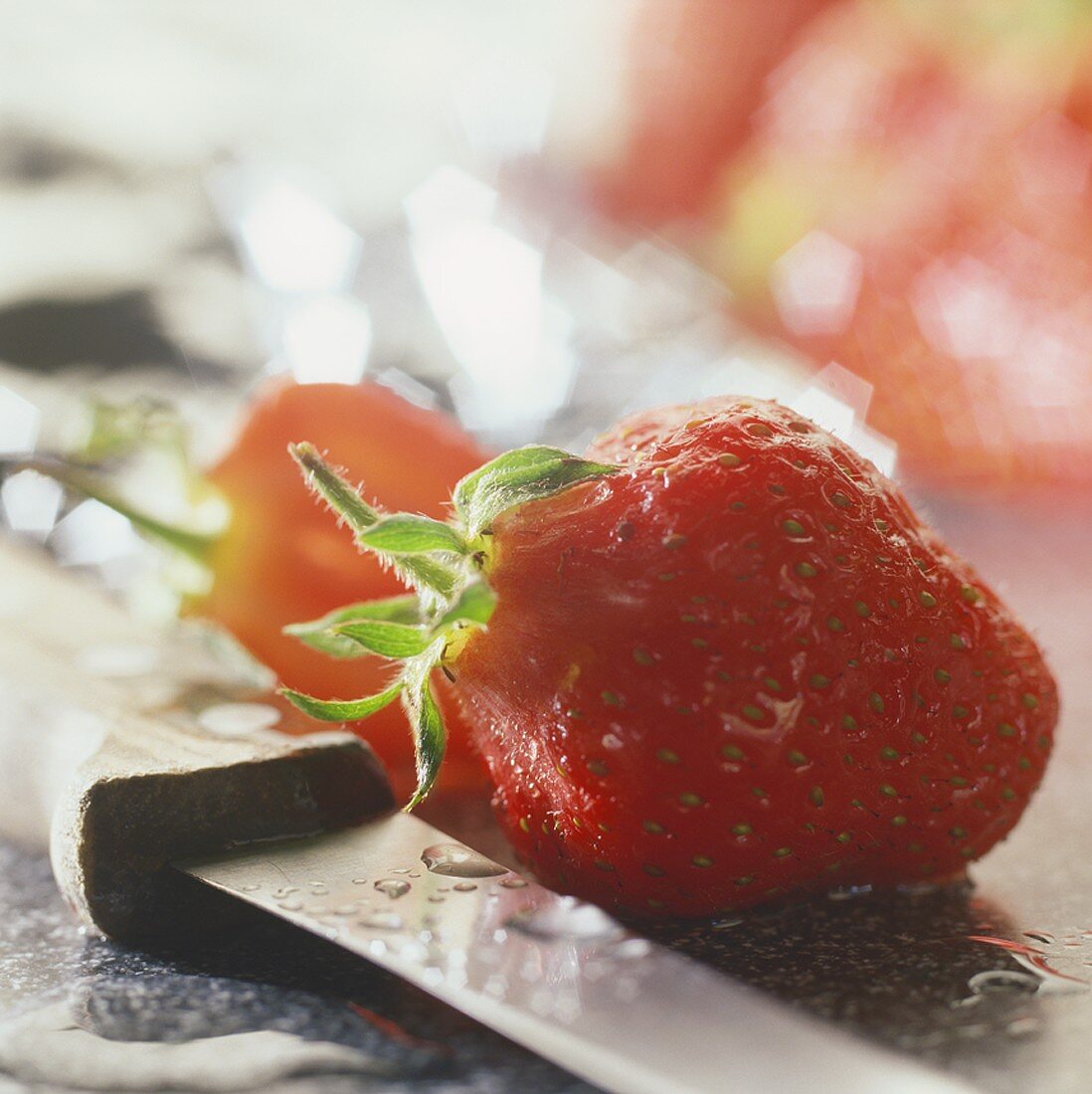 Frisch gewaschene Erdbeere und ein Messer