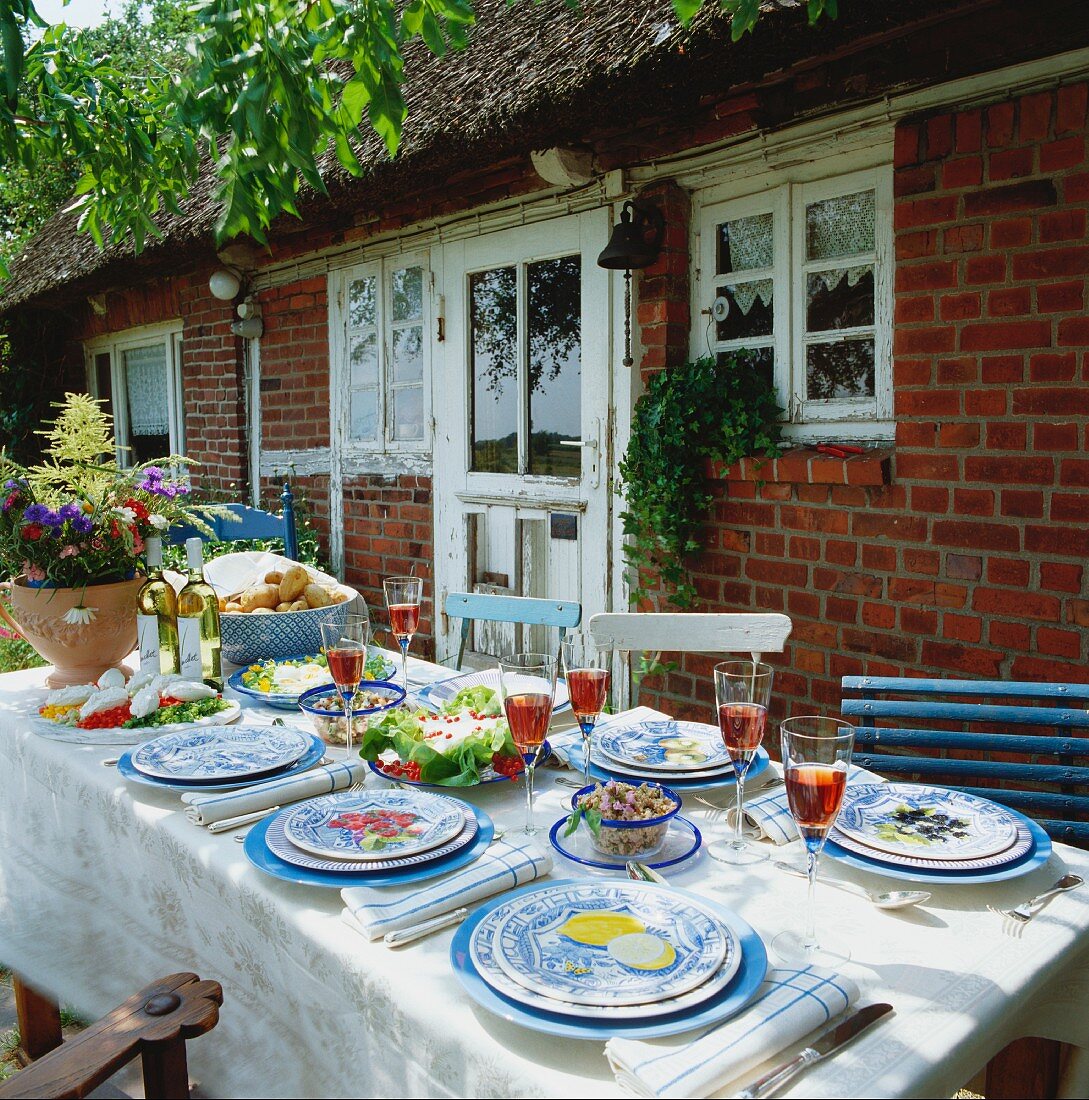 Laid table with food in front of house in country