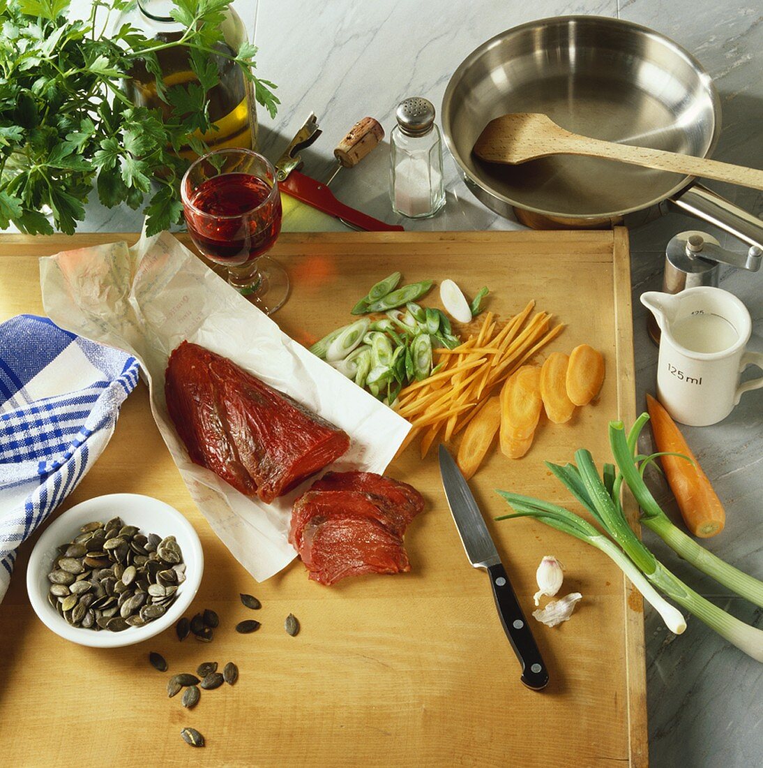 Meat, vegetables, pumpkin seeds etc. on a kitchen board