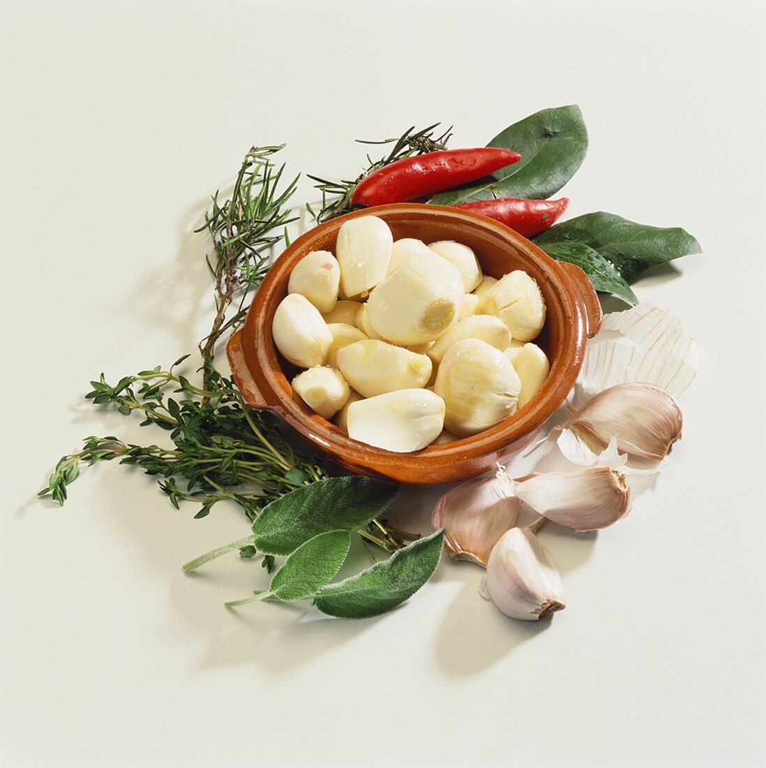 Garlic cloves, fresh herbs and two chillies