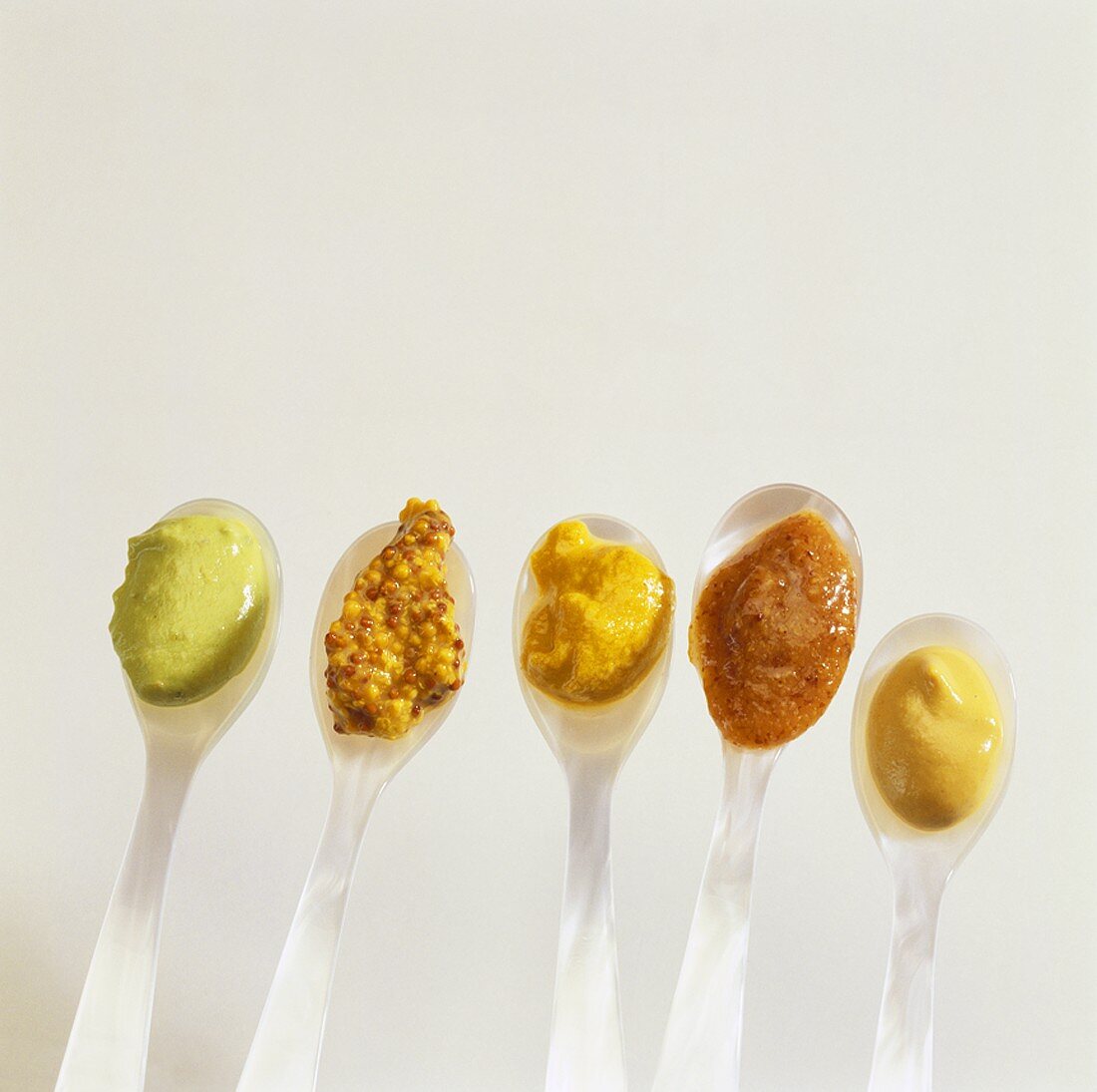 Mustard parade (Various types of mustard on spoons)