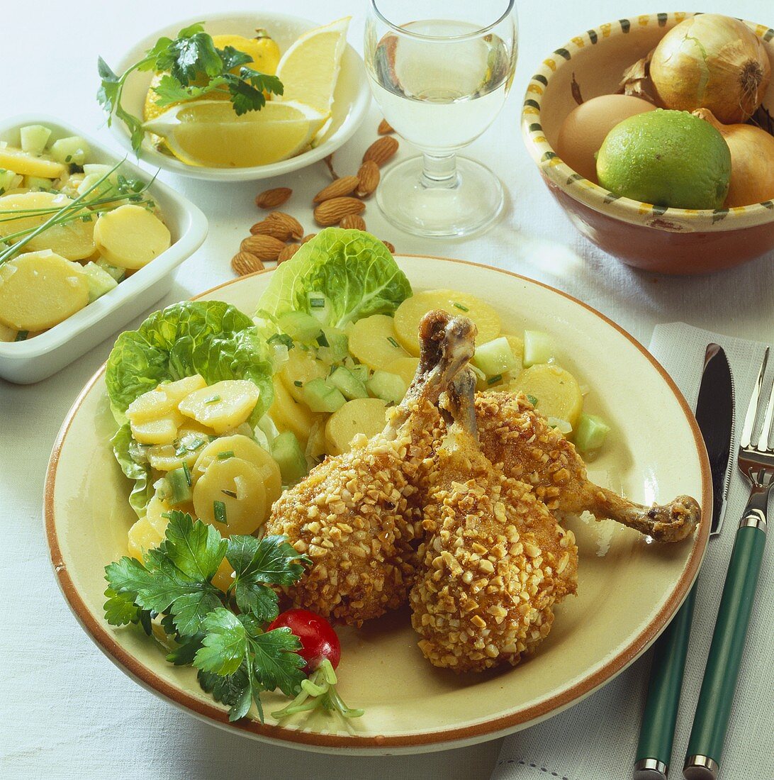 Chicken legs with almond crust on potato salad