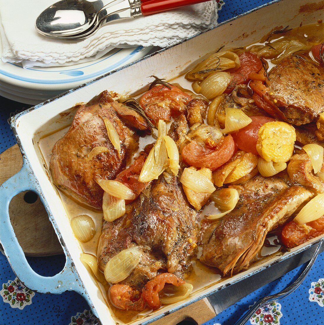 Braised turkey with onions and tomatoes in roasting tin