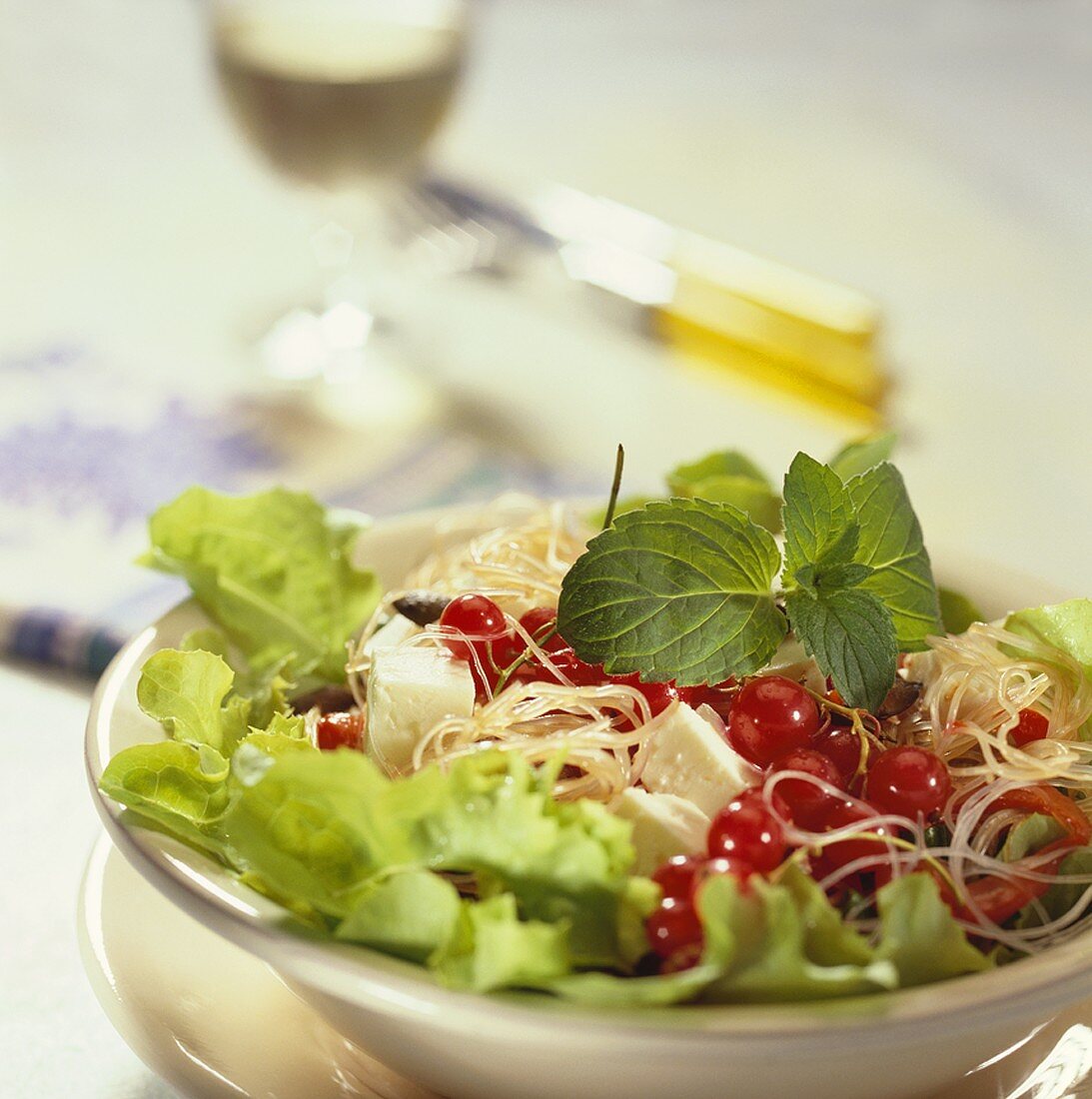 Gourmet salad with glass noodles, cheese and redcurrants
