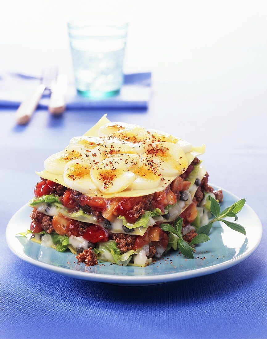 Mince lasagne with salad leaves and potatoes