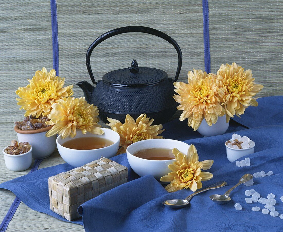 Stillleben mit Tee, Kandiszucker und Dahlien