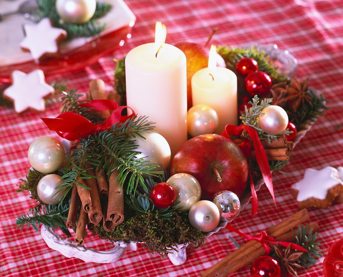 Arrangement of apples, fir sprigs, moss and baubles