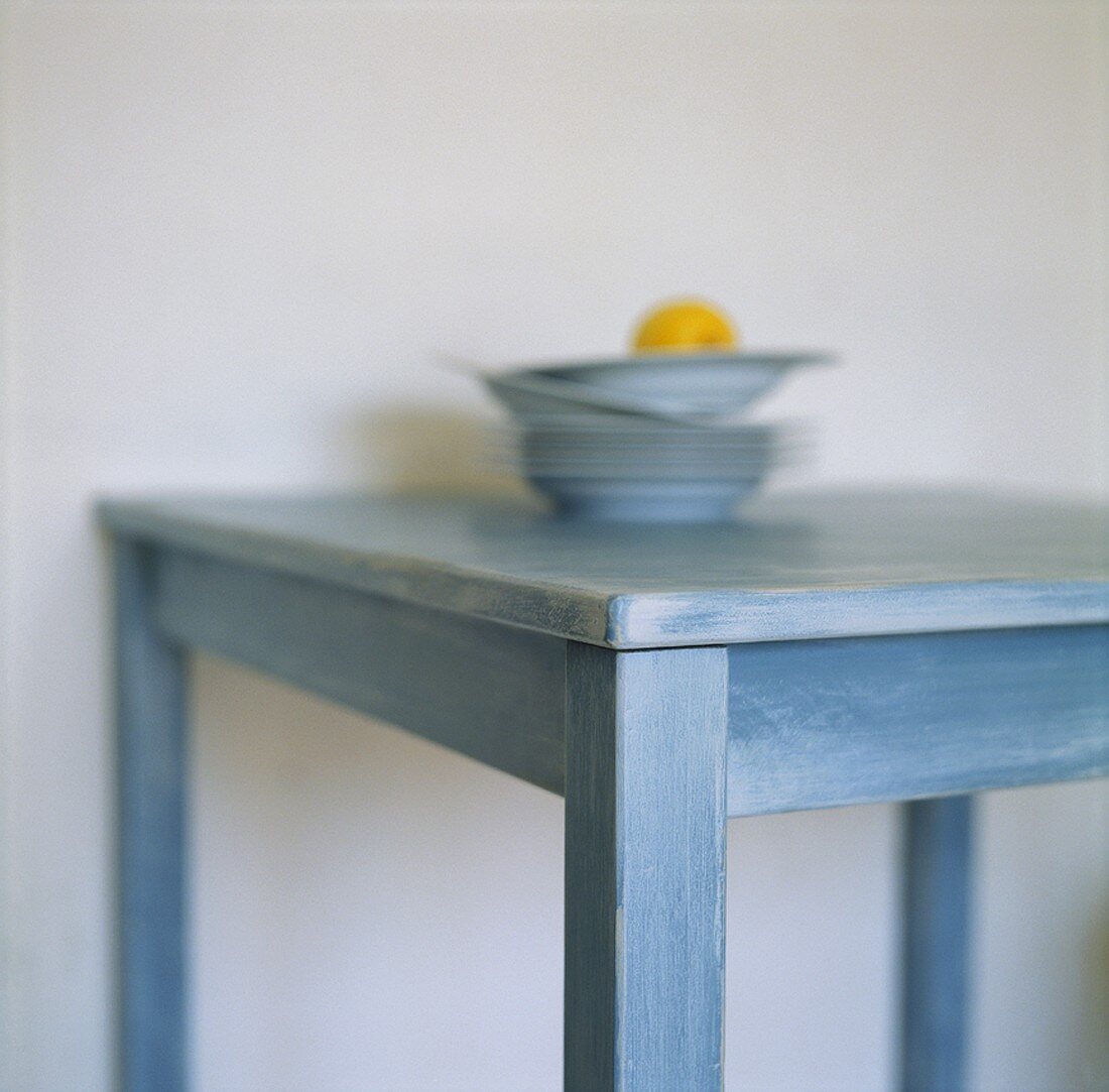 Lemon on stacked plates on a kitchen table