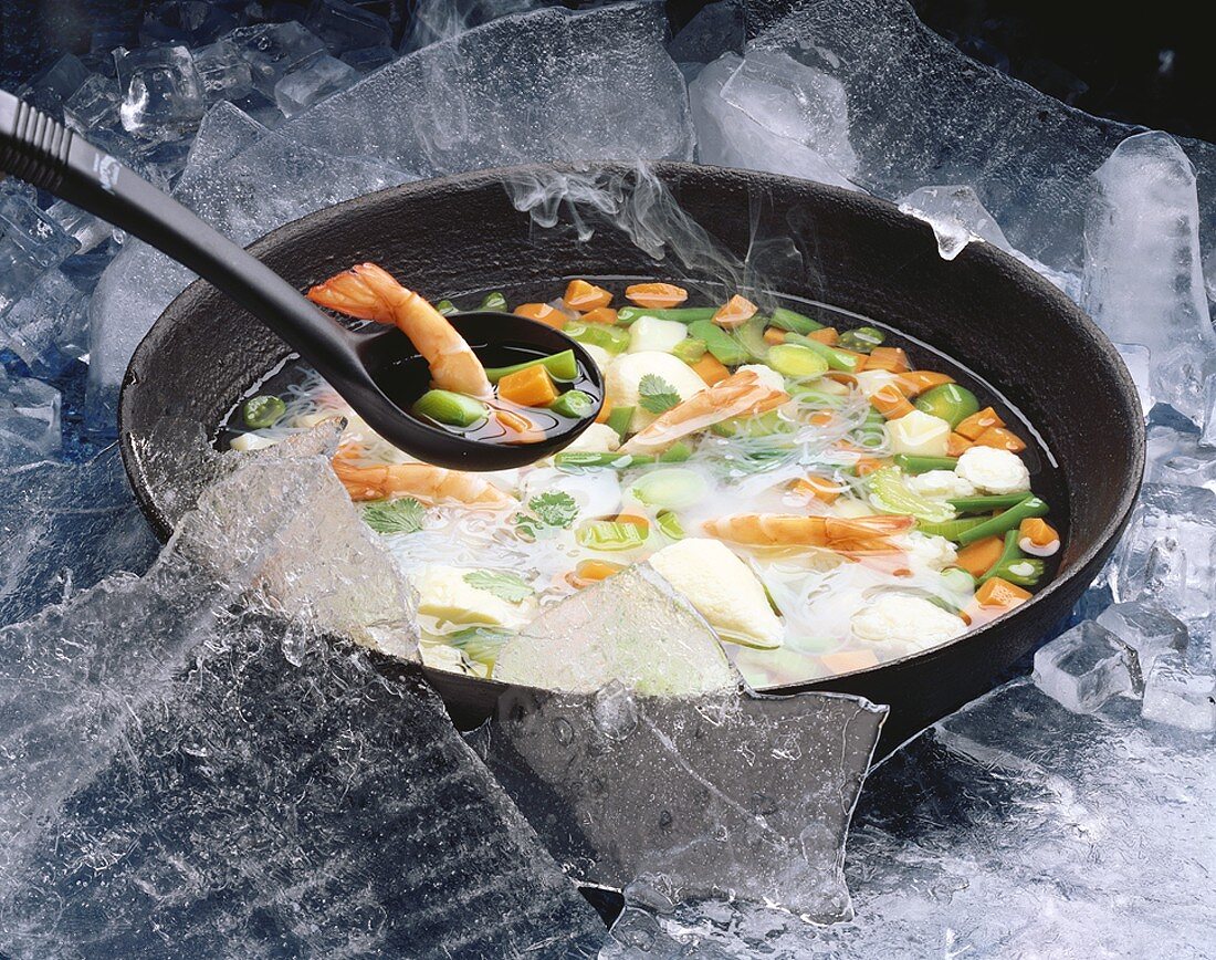 Garnelensuppe mit Gemüse, umgeben von Eis