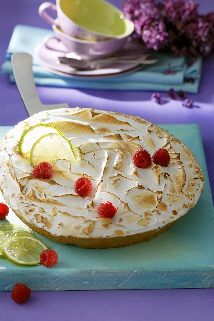 A meringue tart with lime slices and raspberries