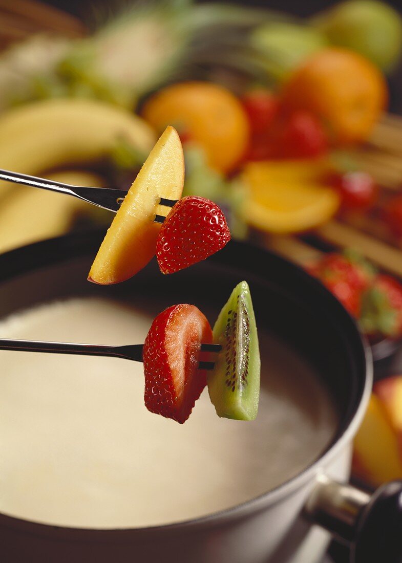 White chocolate fondue with fruit on fondue forks