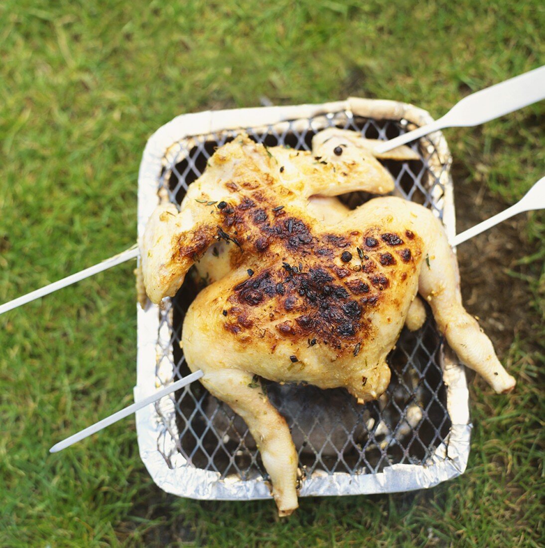 Mariniertes Hähnchen auf kleinem Grill im Freien