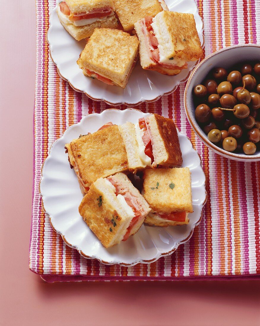 Small toasted ham, tomato and mozzarella sandwiches