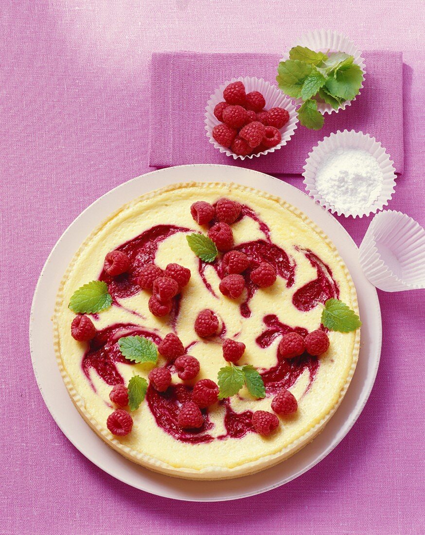 Whole raspberry tart on cake plate