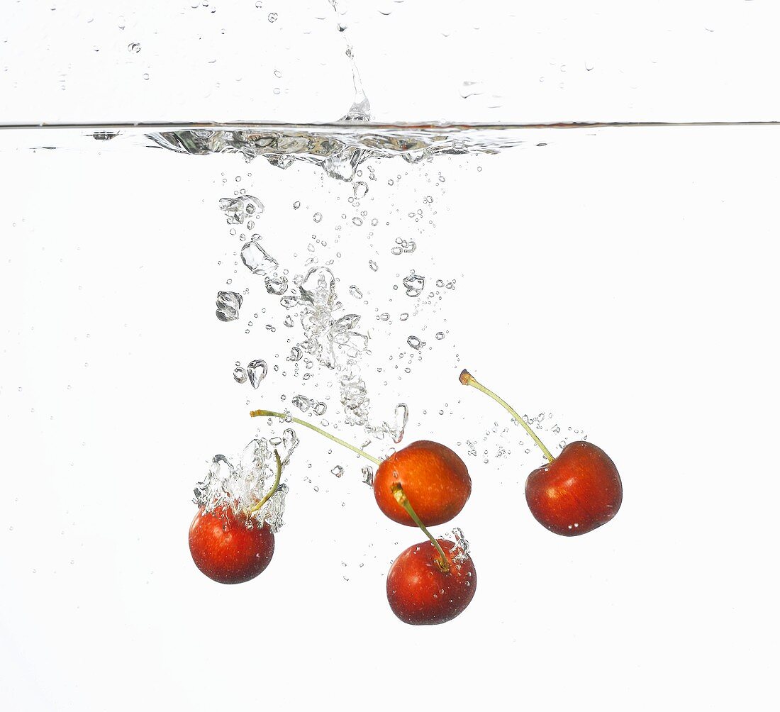 Cherries falling into water