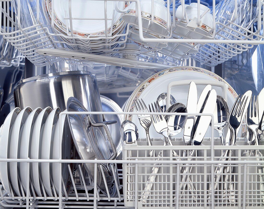 A dishwasher full of clean crockery & cutlery, from inside