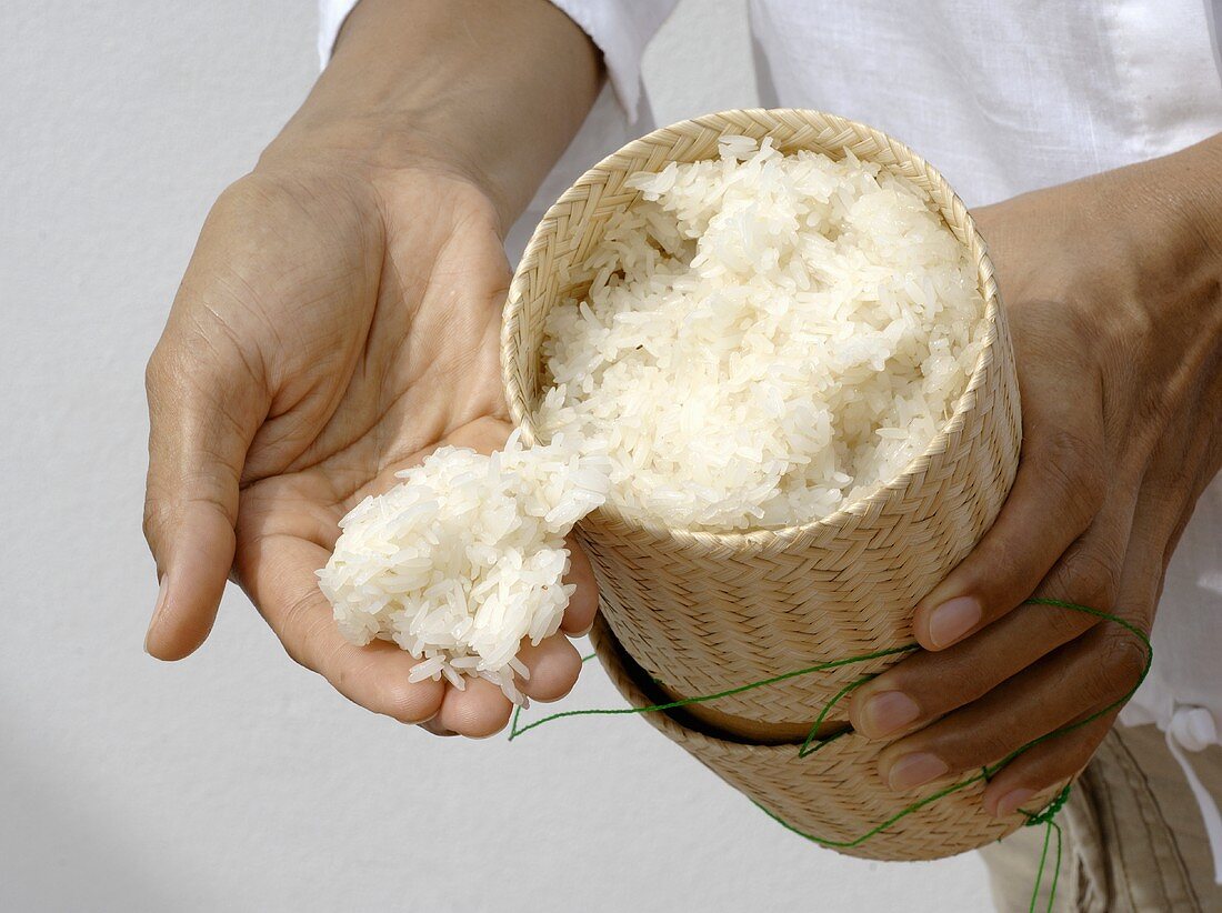 Thai boy holding sticky rice in his hand